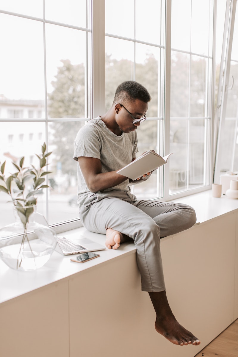 A Man in Gray Shirt Reading a Book
